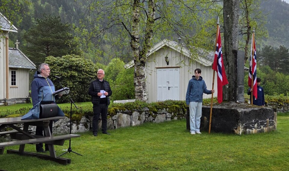 Bernt G. Bøe las diktet «Ingen Lit de Parade». En mann som taler ved ei kirke og et minnesmerke.