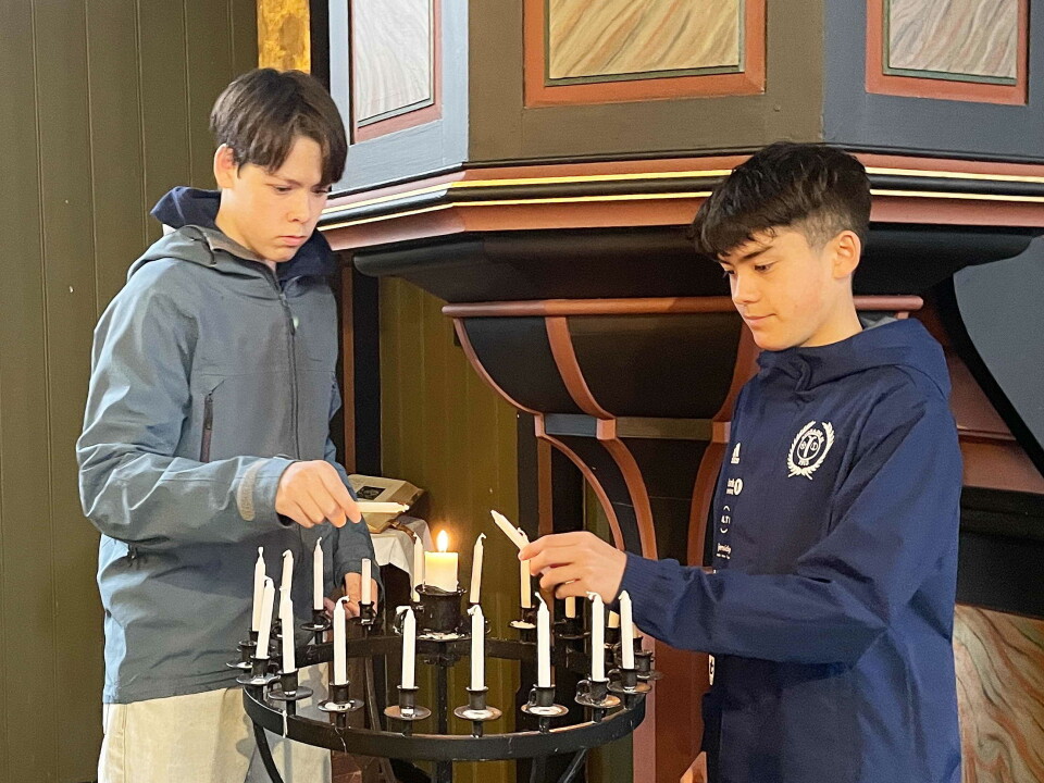 Todalen: Konfirmantane Trygve Aleksander Halle (t.v.) og Jens Sancho Ansnes tenner minnelys for soldatane Gunnar, Halvor og Anton. To gutter tenner lys i kirke