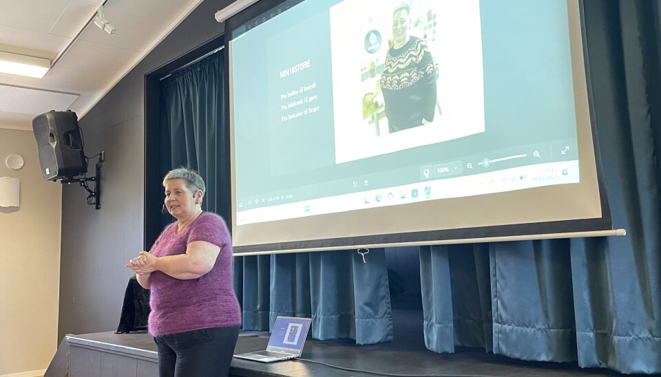 Marit fenger publikum med sitt sterke engasjement for garn og nisjebutikker. En dame i lilla strikkegenser står foran en storksjerm.