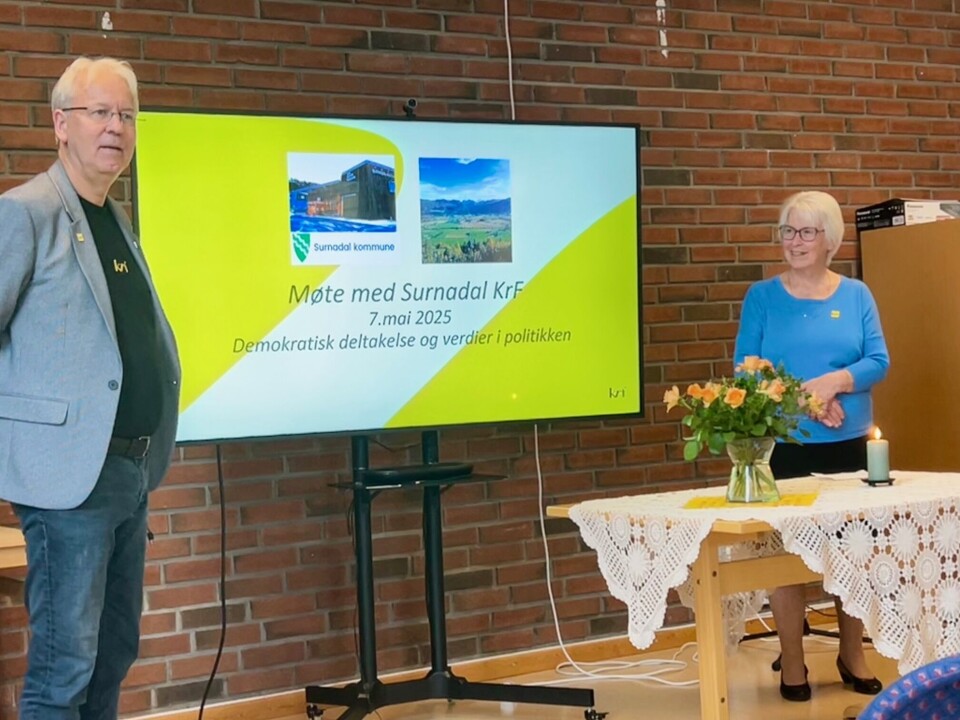 Aurka-ordfører Helge Kjøll (KrF) holdt dagens innlegg om demokratisk deltakelse og verdier i politikken. Mann og dame foran skjerm som viser overskriften 'Møte med Surnadal KrF'