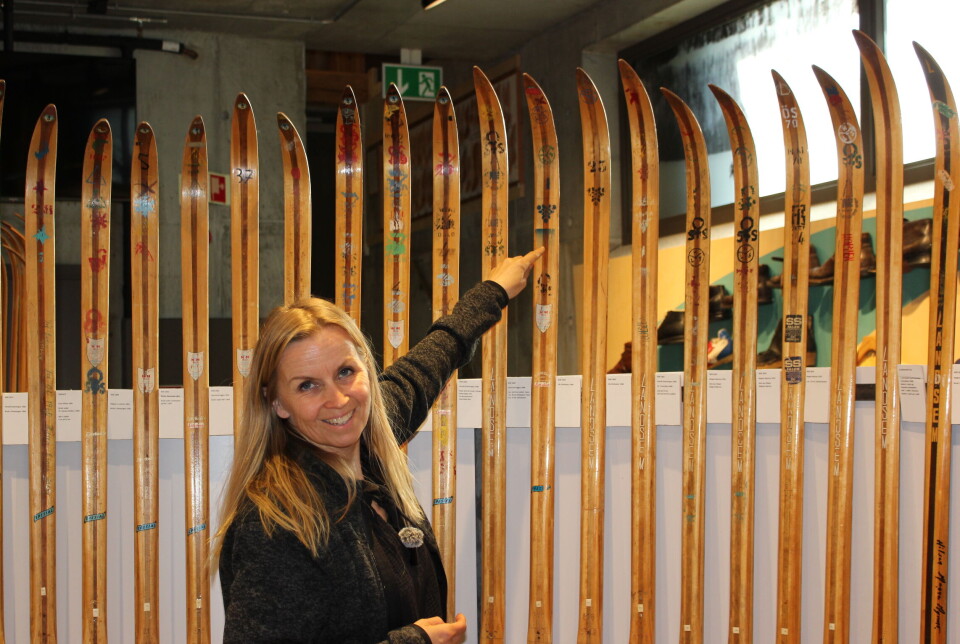 Av stempler eller sklistremerker på skiene kan en også se hvilke mesterskap eller konkurranser skiene har vært benyttet. Dame peker på stempel på et par ski.