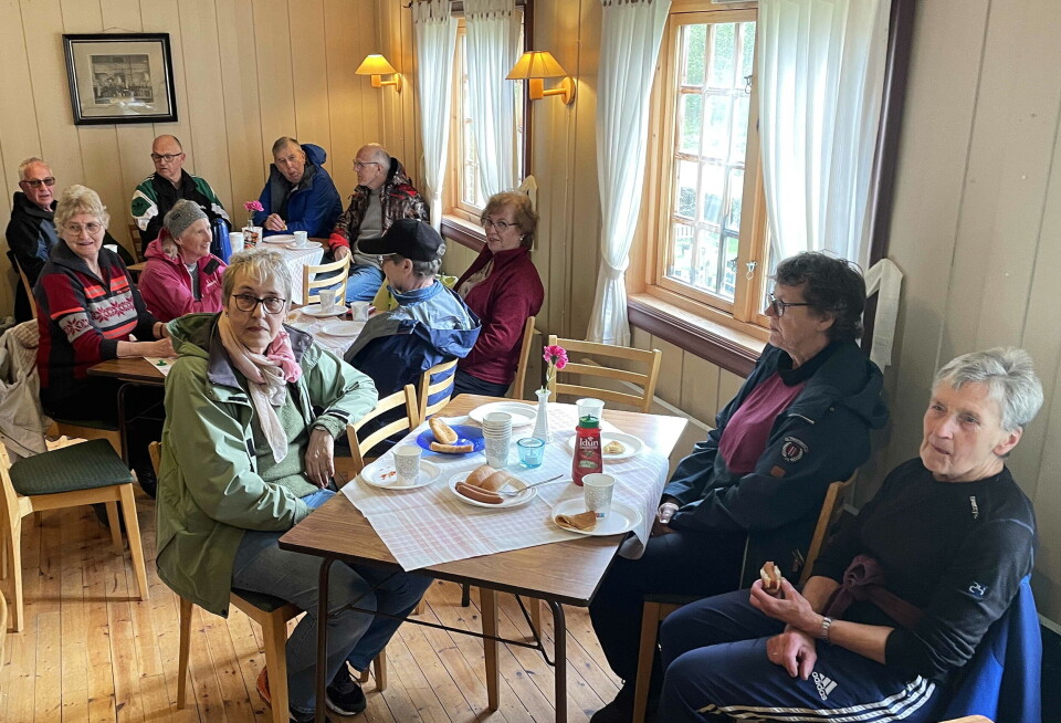 Samling etter endt dugnad. Flere personer rundt kaffebord.