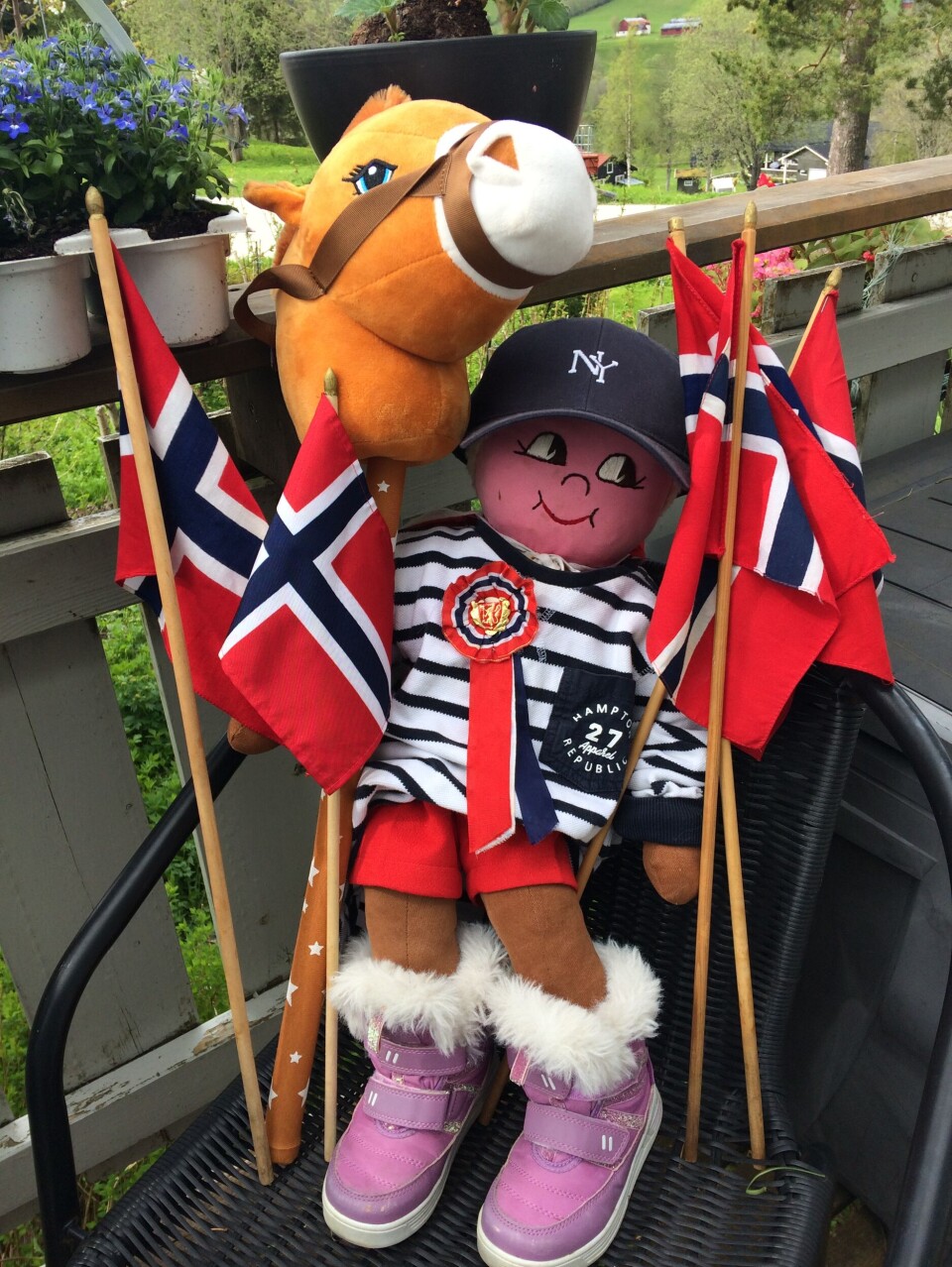 Dukkemann sto opp tile, å va klar te å feir den 17.! En dukke, en kjepphest og mange norske flagg i en campingstol.