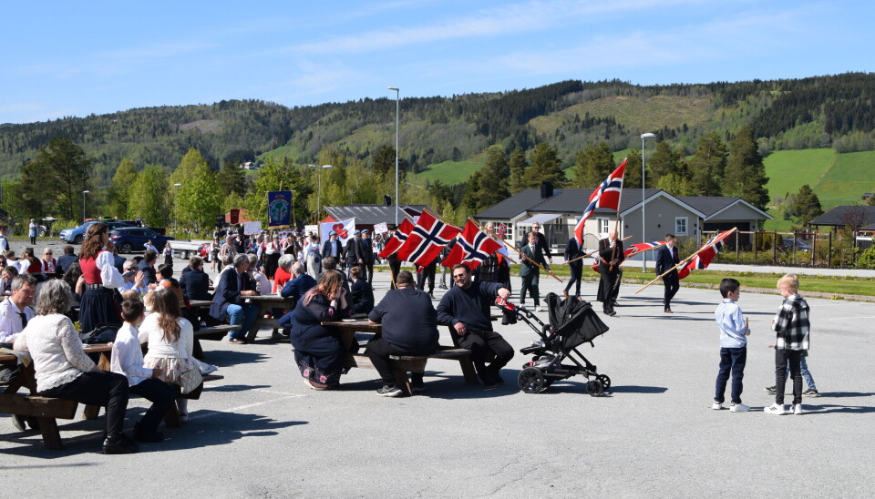 Folketoget ankommer Rindalshuset. Mye folk og flagg på 17. mai.