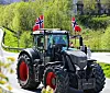 En traktor pyntet med norske flagg på taket.