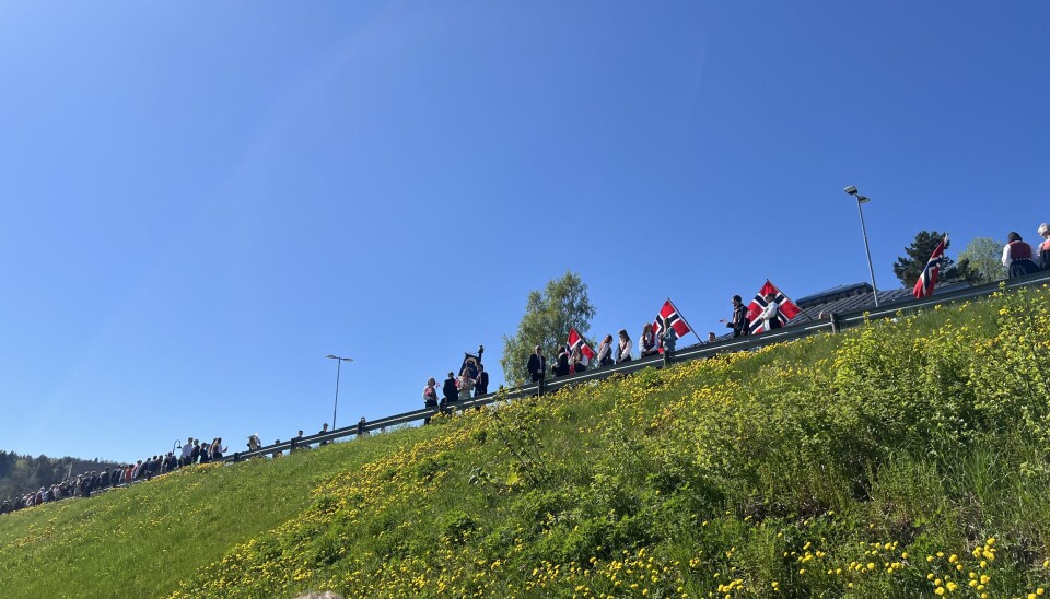 folk med flagg langs autovern
