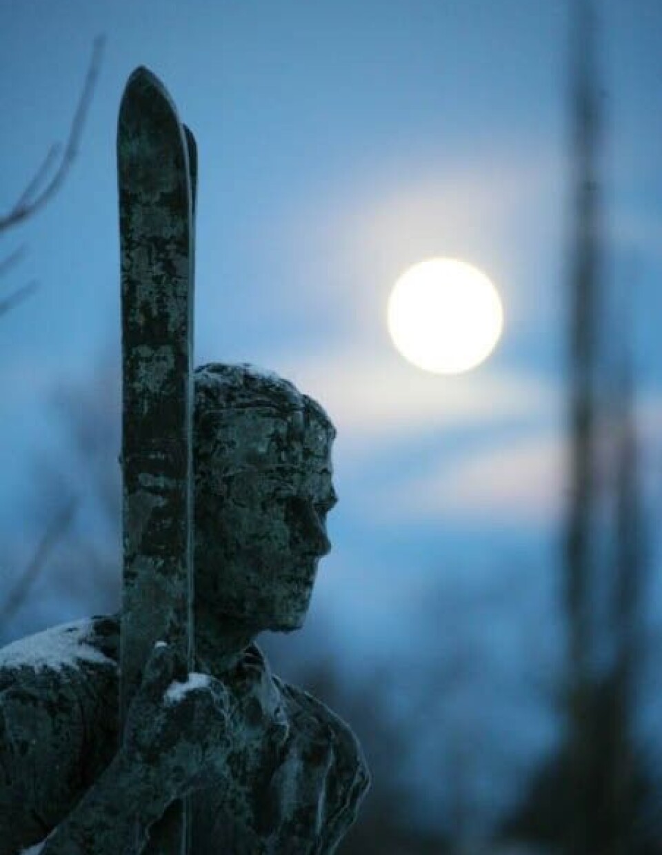 Sigurd Røen. En statue av en mann som holder et par ski.