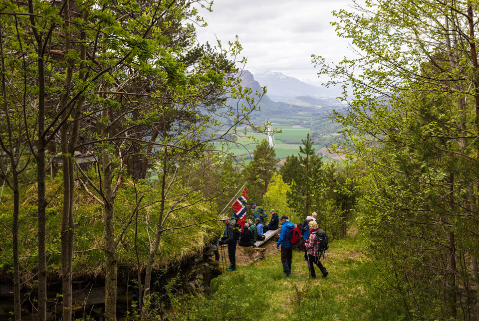 Ved Fjelldalsgamma (Malibu). Turgåere ved ei hytte/gamme i skogen.
