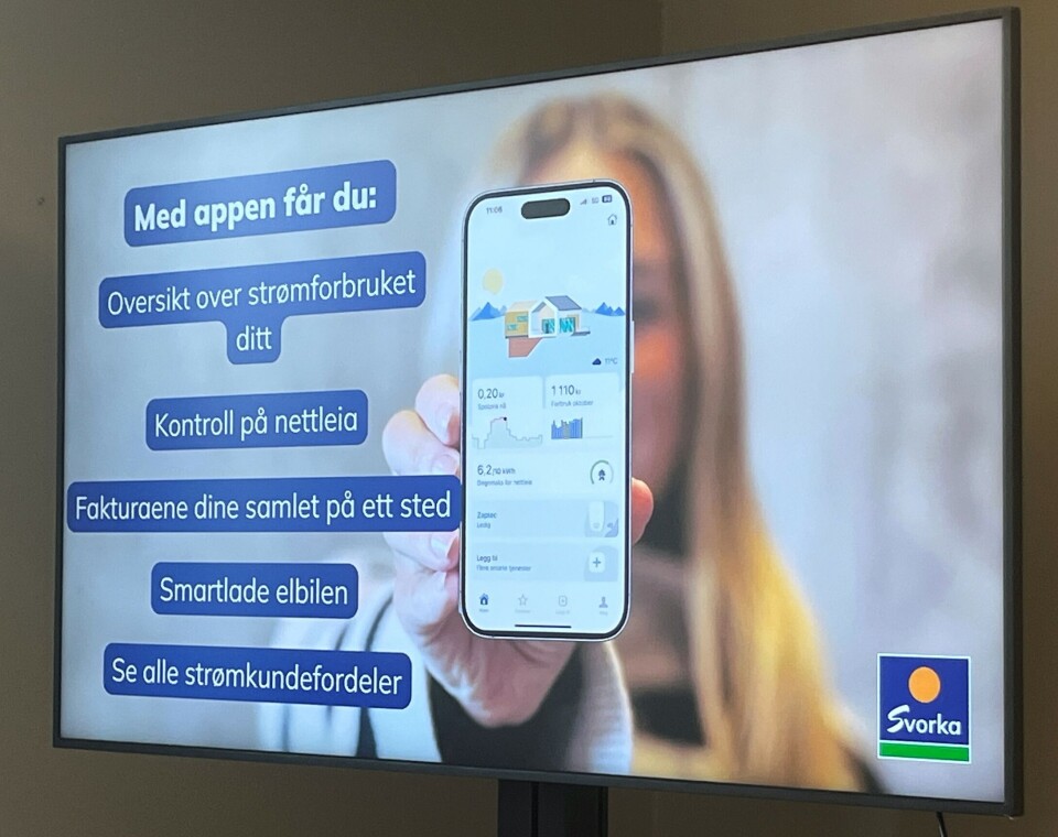 Svorka-appen gir god oversikt over (nesten) alt som har med strømforbruk å gjøre. Bilde av en storskjerm. Det vises et bilde av ei dame som holder fram en telefonskjerm.