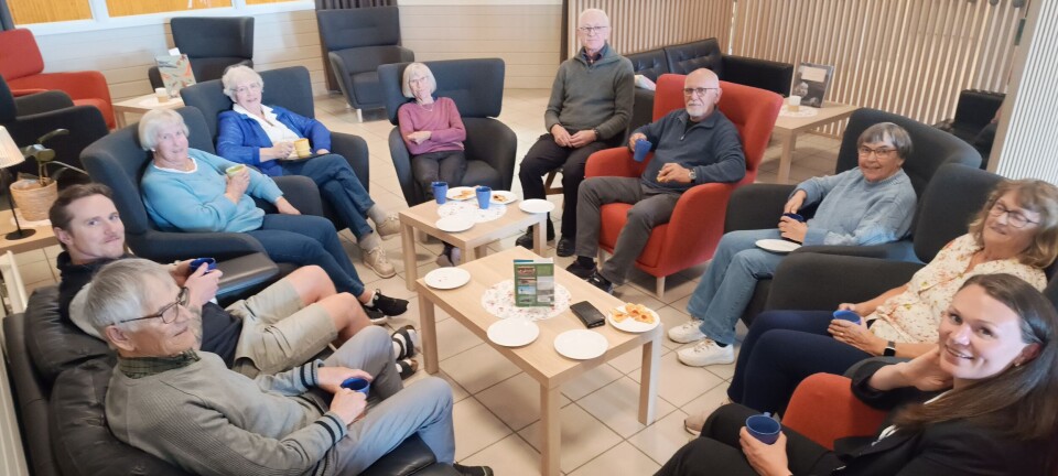 Trivelig møteavslutning med kaffe og bakels. Flere personer rundt et kaffebord.