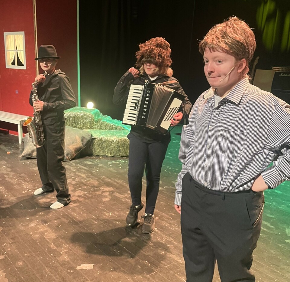 Fra fjorårets forestilling. Tre barn utkledd som voksne på en scene.