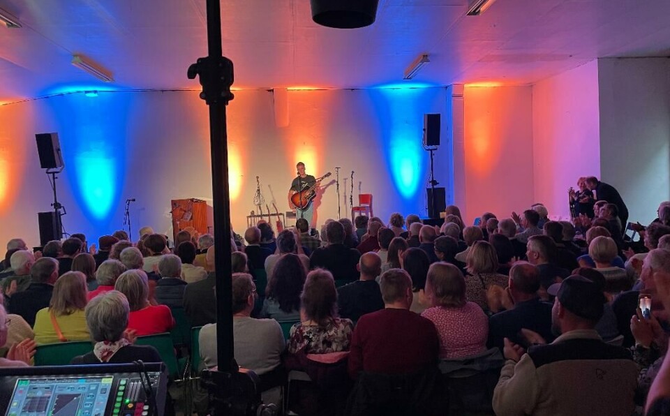 Tore Bredesen imponerte med sine talenter både i sang og gitarspill. Ungdom med gitar på en scene. Han står bak en mikrofon.