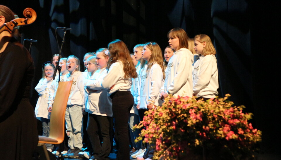 Barnekoret Amigos berika konserten. barnekor synger med hvite gensere