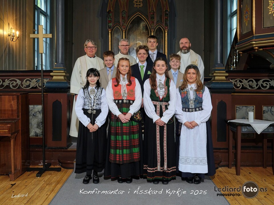 Konfirmantane i Åsskard saman med sokneprest Pål Arne Winsnes, kateket Odd Erik Stendahl og prost Vidar Wilhelmsen Rygh. Ni konfirmanter og tre prester oppstilt for fotografering i kirka.