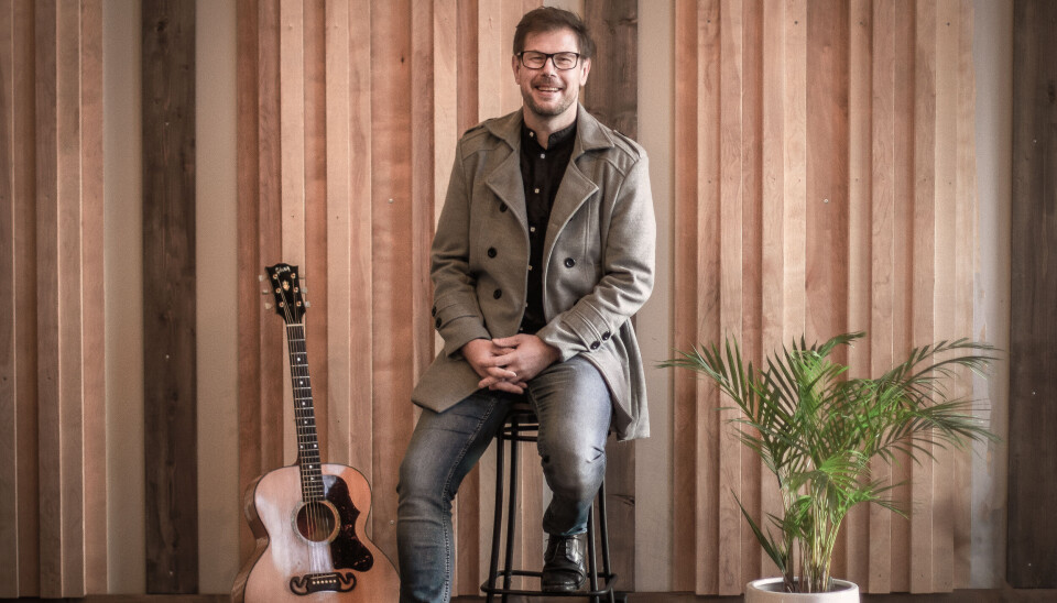 Karstein Mauset er klar for å skape god stemning Mann på krakk ved gitar