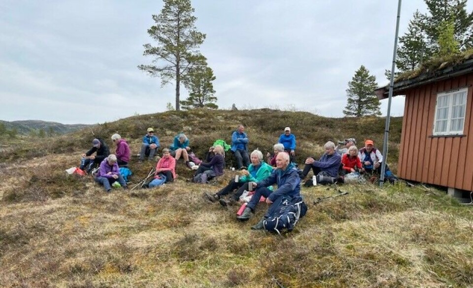 Matpause. Ei gruppe turkledde folk som har matpause ved ei seter.