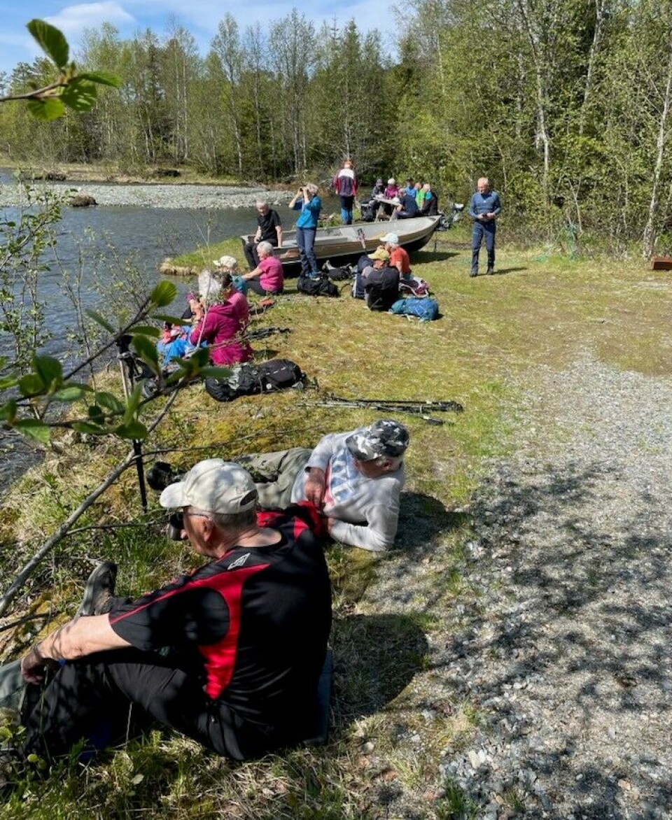 Siste rast ved Kysingvatnet. Ei gruppe turkledde folk som hviler ved et vann i marka.