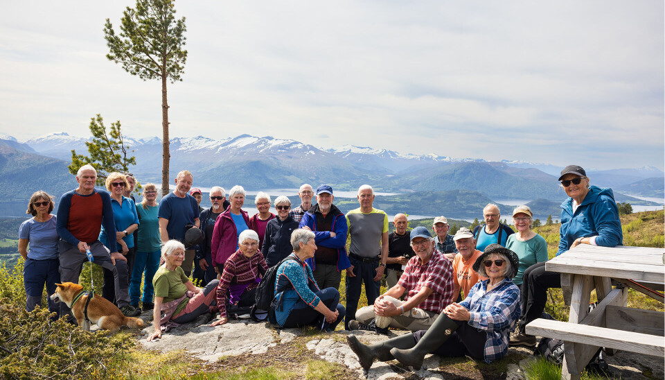 25 av alle 27 samla på Klåberget. 25 turkledde mennesker med utsikt mot fjord og fjell.