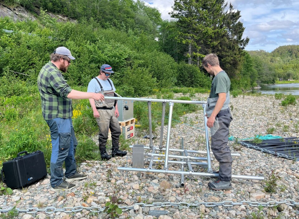 NINAs folk monterer stativ for sonaren. Tre menn som monterer et stativ av metall.