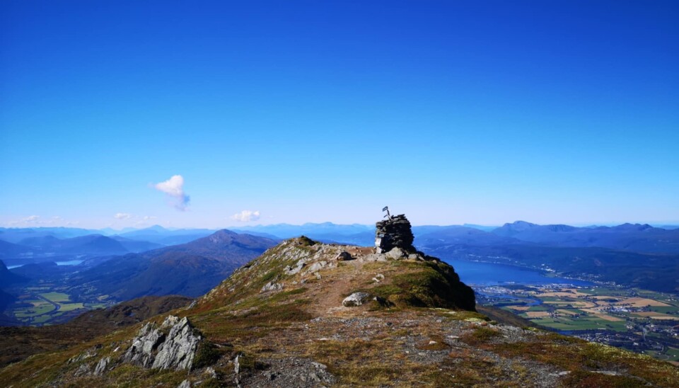 Knyken 06.09.2022 Toppen av et fjell. Varde av stein. flott utsikt mot fjord, fjell og åkrer.