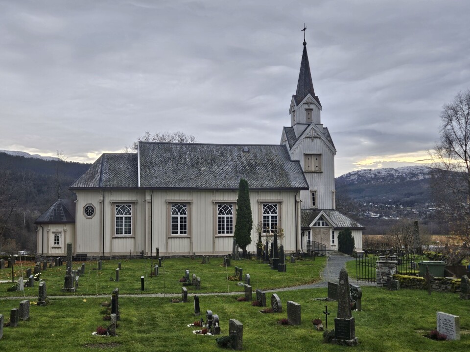 Øye kyrkje Bilde av trekirke med kirkegård foran