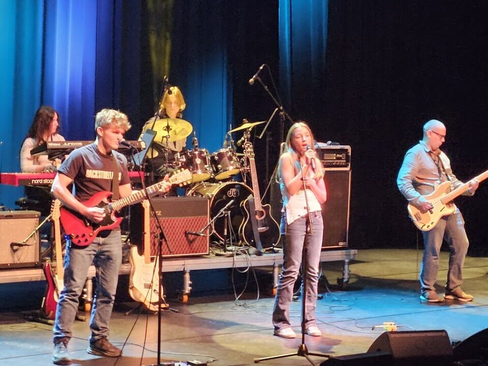 Kunst og musikk i kulturhuset med lovende lokale stjerner Mennesker som opptrer på en scene.