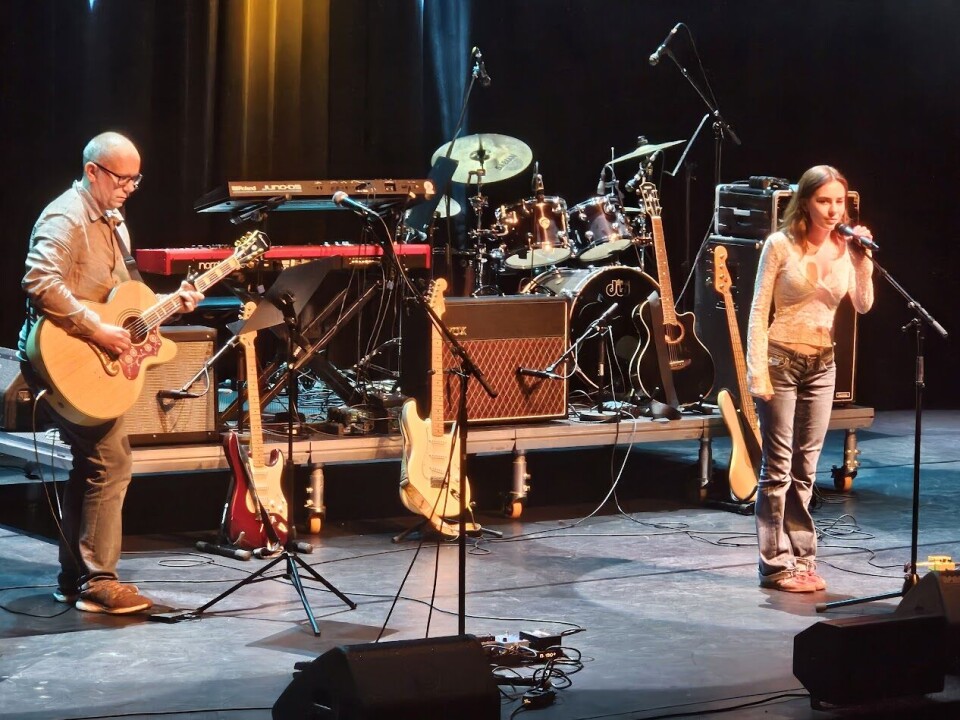 Kunst og musikk i kulturhuset med lovende lokale stjerner Mennesker som opptrer på en scene.