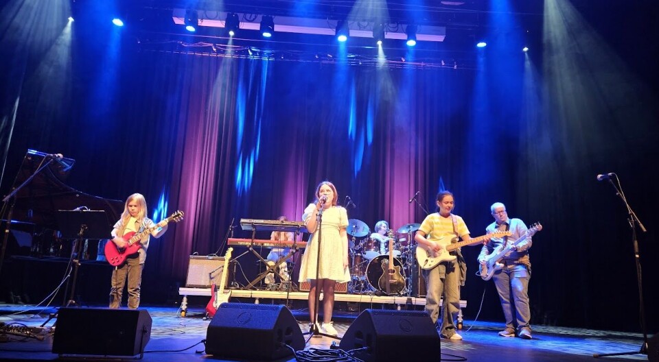 Kunst og musikk i kulturhuset med lovende lokale stjerner Mennesker som opptrer på en scene.