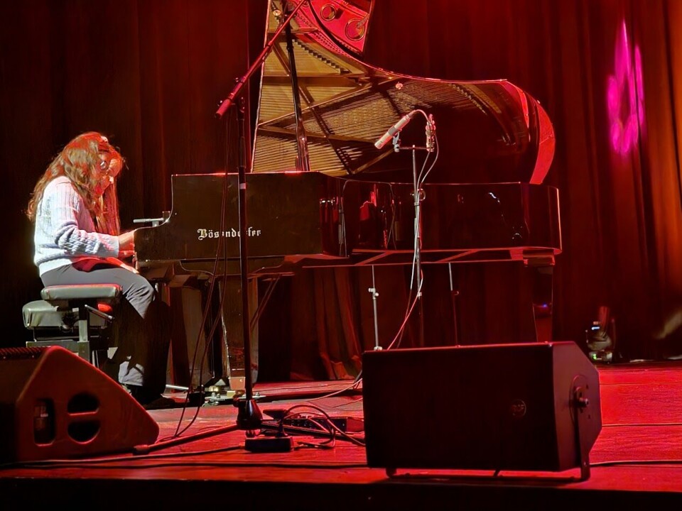 Kunst og musikk i kulturhuset med lovende lokale stjerner Mennesker som opptrer på en scene.