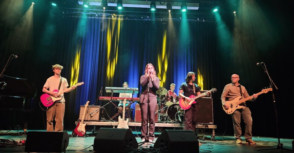 Kunst og musikk i kulturhuset med lovende lokale stjerner Mennesker som opptrer på en scene.