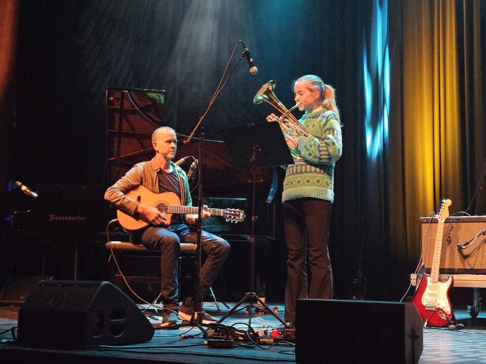 Kunst og musikk i kulturhuset med lovende lokale stjerner Mennesker som opptrer på en scene.