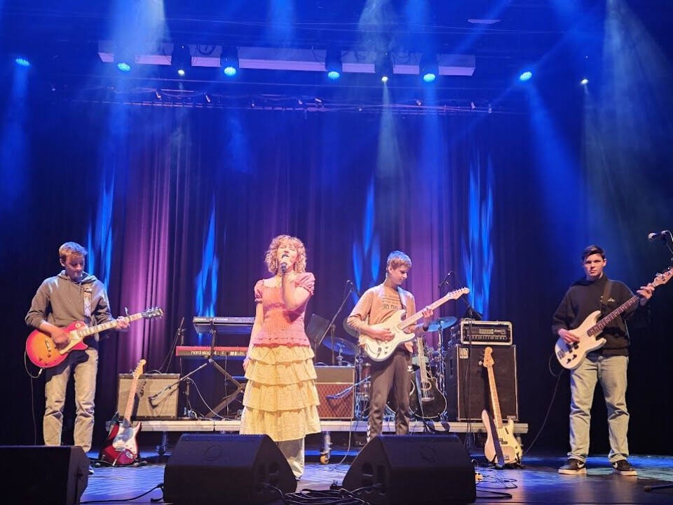 Kunst og musikk i kulturhuset med lovende lokale stjerner Mennesker som opptrer på en scene.