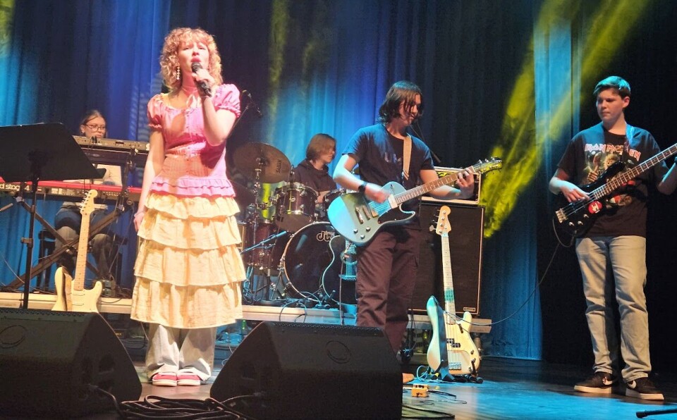 Kunst og musikk i kulturhuset med lovende lokale stjerner Mennesker som opptrer på en scene.