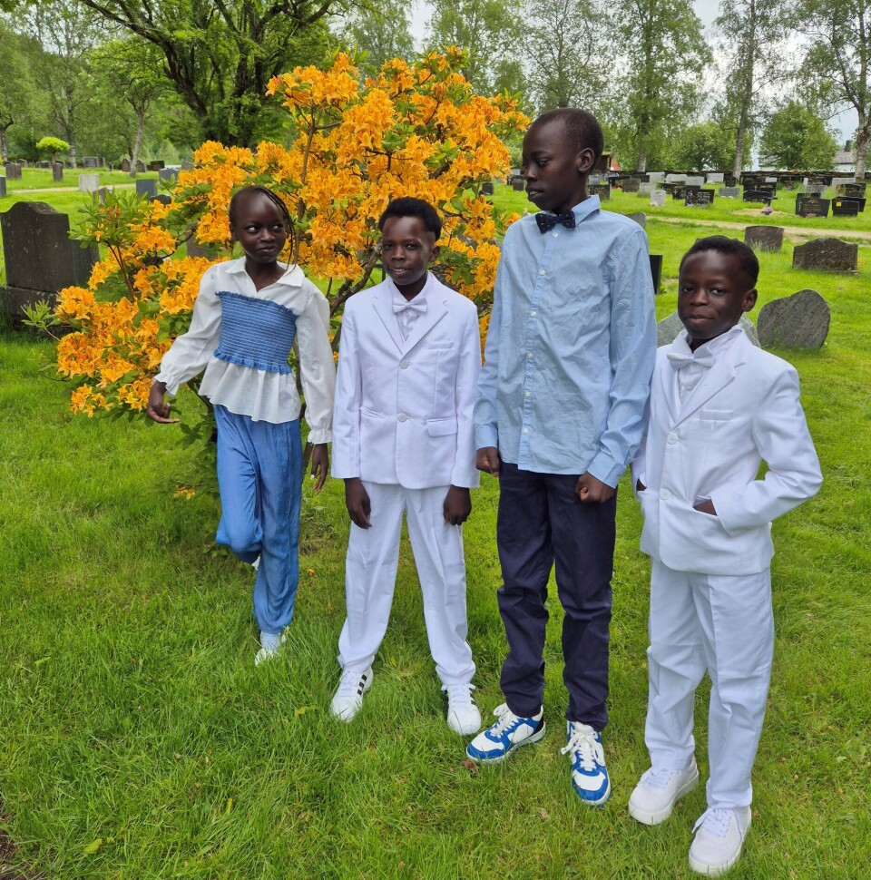 Mary, Justin, Emmanuel og Iwan etter 1.communion og konfirmasjon i Øye kirke 7.juni. Fire ungdommer stående i en hage