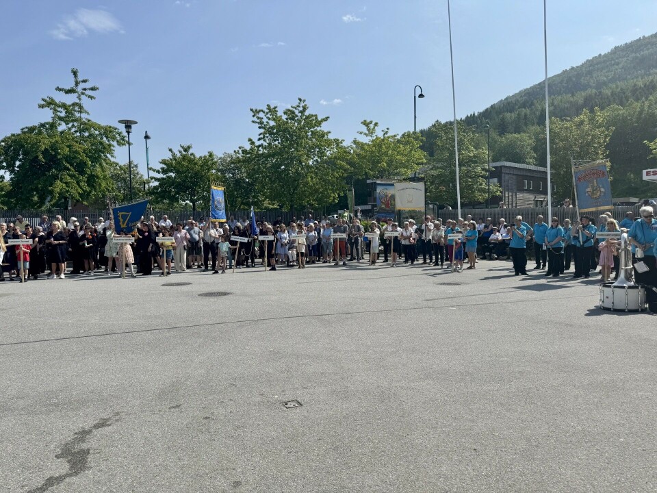 Mennesker som står samlet på en plass.