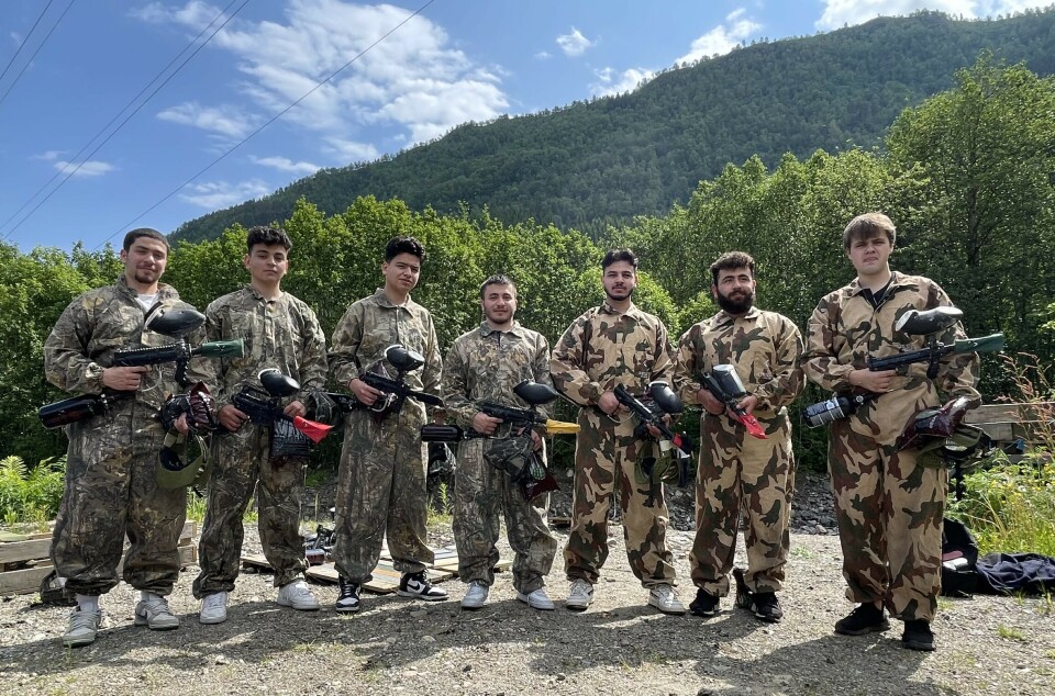 Denne ungdomsgjengen er klar for kamp på paintballbanen på Ranes 7 unge menn i kamuflasedrakt med hvert sitt paintballgevær i hendene. Skog i bakgrunnen