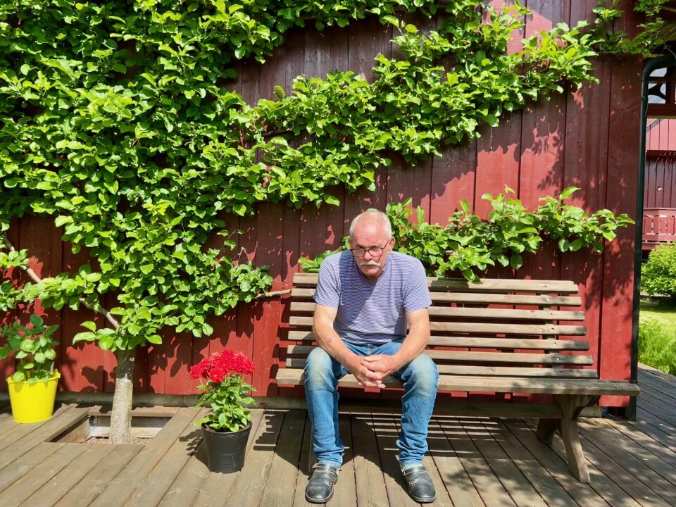 Magne trives best med spaden i neven, i følge ham selv. Så lenge helsa holder, vil han fortsette å grave i jorda, klippe gress og beskjære frukttrær. Eldre mann på benk ved et epletre som vokser i en husvegg