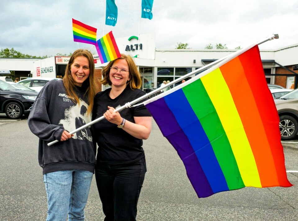 Yana Smelyk (t.v) og Siv Torvik står for pride-arrangementet i Surnadal i år. To kvinner står ved siden av hverandre foran Alti kjøpesenter. Sammen holder de et regnbueflagg.