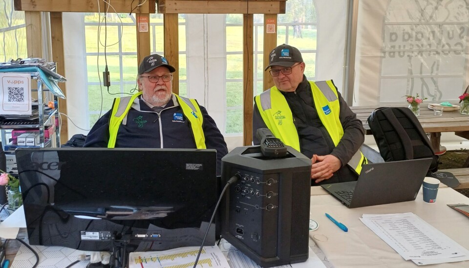 Sekretariatet - her ved Emil Naterstad og Birger Johnsen To menn i caps og gul vest bak et bord med PC