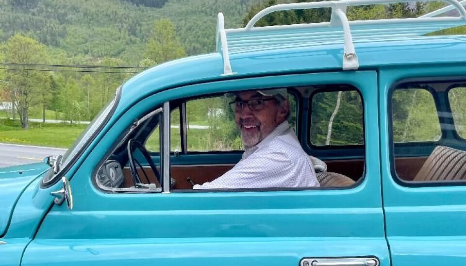 Oddvar Kvande Mann sitter i en veteranbil.