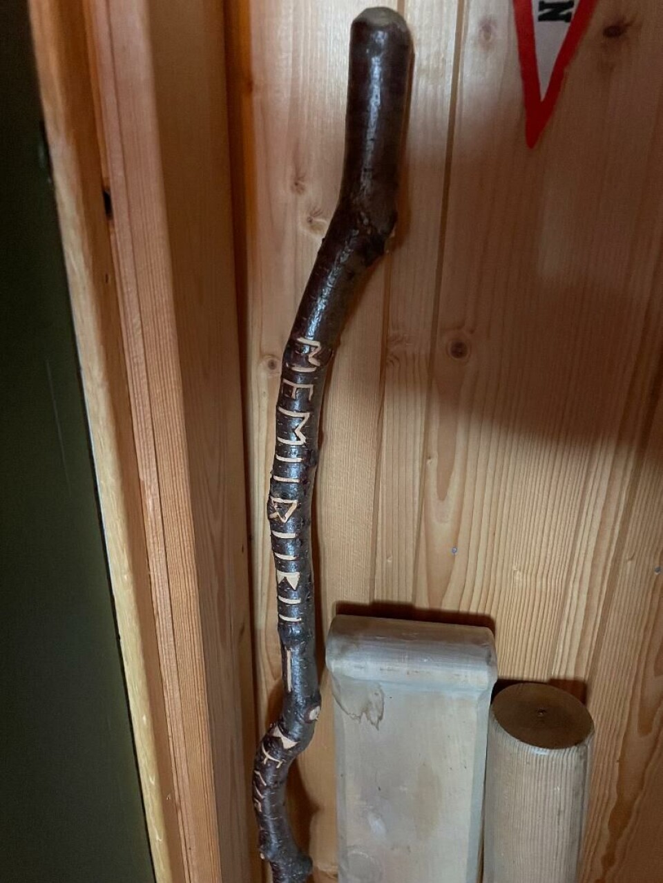 Denne staven står rett innenfor døra ved trappa når du kommer inn til garasjeloftet. Staven er fra Besseggen, og Oddvar har skrevet på den ved å risse inn bokstaver med en kniv - 'Memurubu - Besseggen'. Stav med innskæringer.