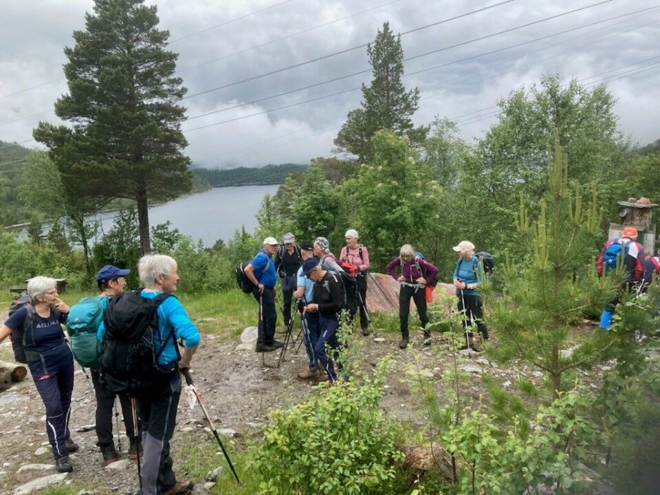Rennsetvatnet til venstre. Ei gruppe turkledde folk som har tatt en liten pustepause på turen.