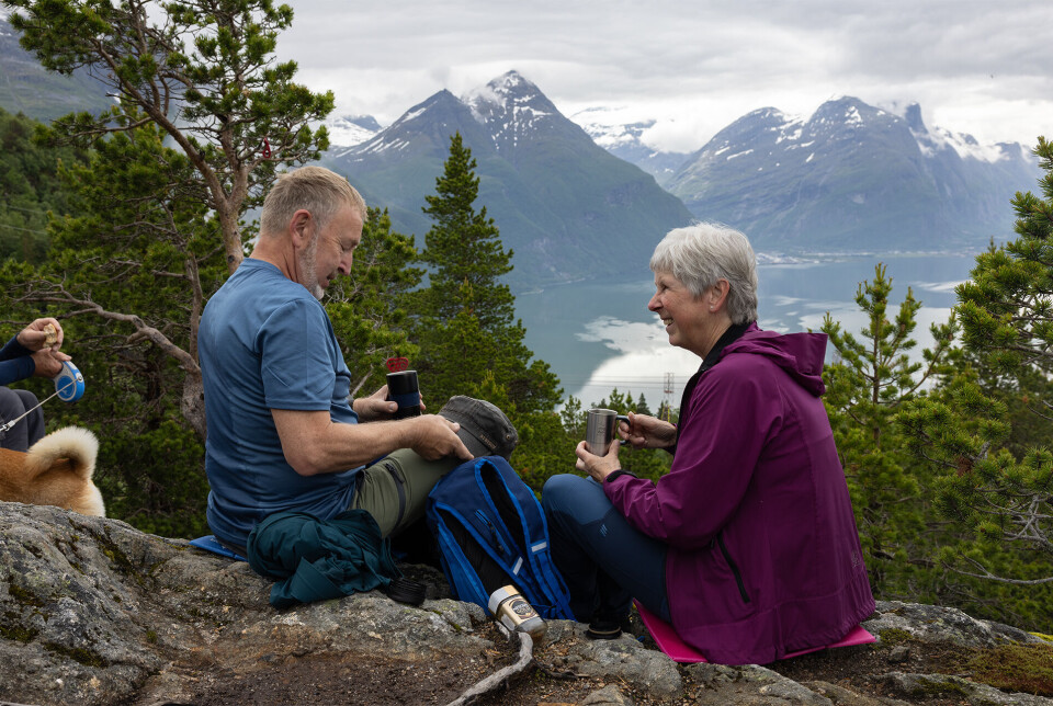 På Karihaugen 487 moh., med god matpause. Noen turgåere som har satt seg ned på noen steiner og nyter utsikt over fjord og fjell.
