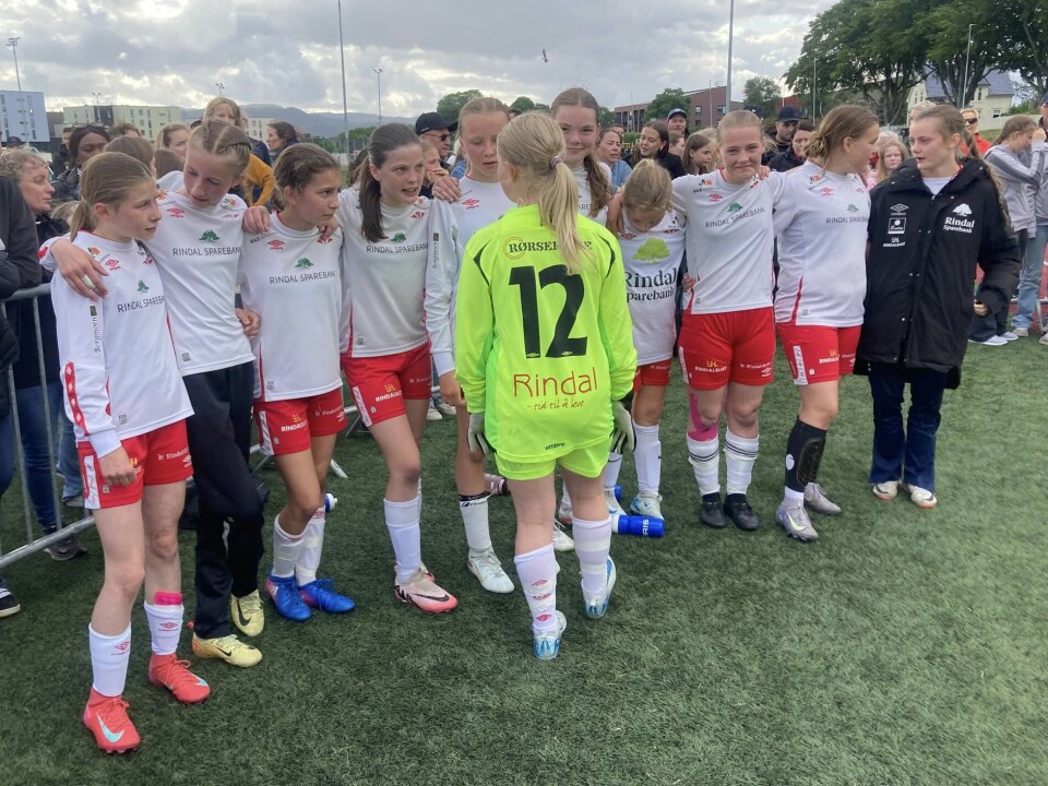 Fokusert gjeng under straffekonken Jenter i hvite fotballtrøyer og en i grønn keepertrøye