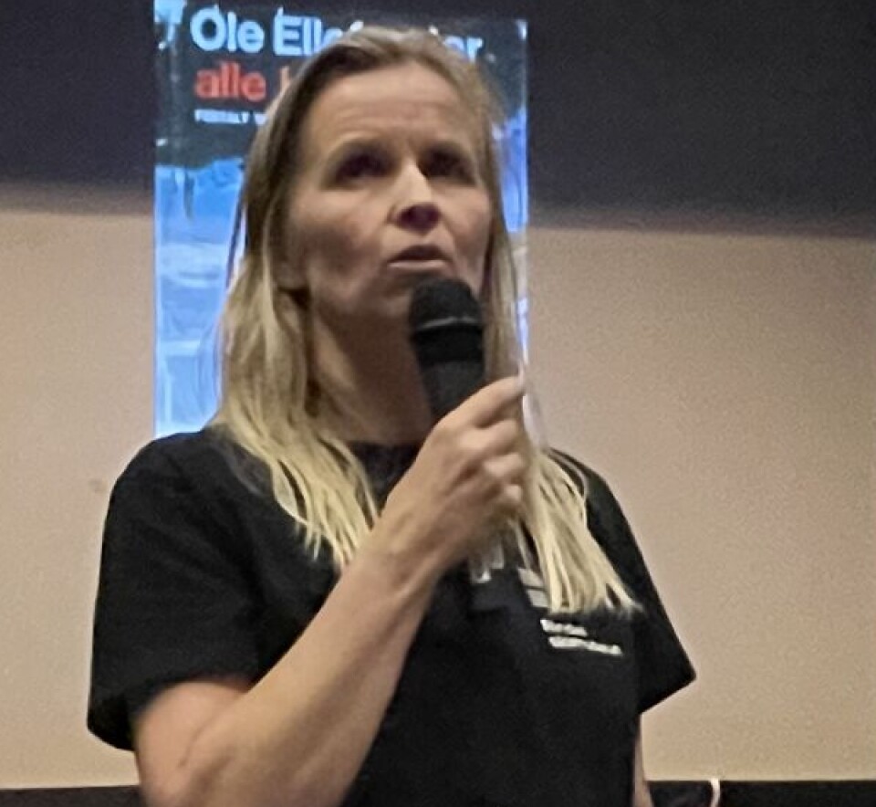 Bodil Børset ønsker velkommen til temakveld i Attanova En kvinne står foran en scene med en microfon i hånden