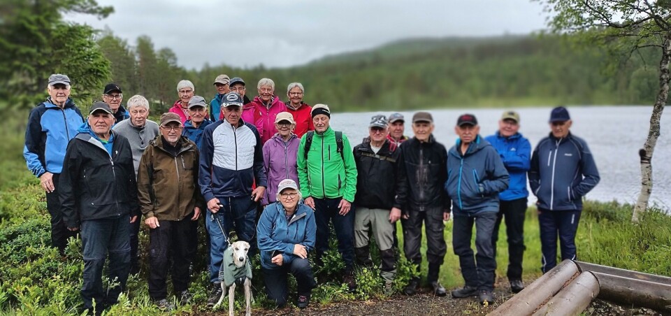 Fra gapahuken med Storvatnet i bakgrunnen. Flere turkledde folk oppstilt til fotografering.