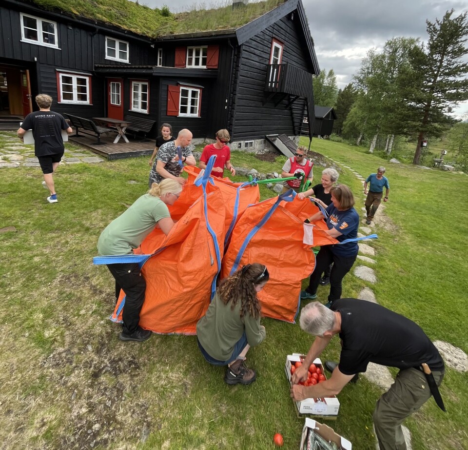 Helikoptertransport til sesongåpning. Her må alle hjelpe til for å tømme bigbagger før neste hiv kommer om 10-12 min. Dugnadshjelpere Mette, Berglijot, Anders og Tore, Jesper fra hovedkontoret og hyttas ansatte Hege, Lukaz, Håvard, Rikke, Guénolé og Oda. Flere personer som samarbeider om ett eller annet på et gårdtun.