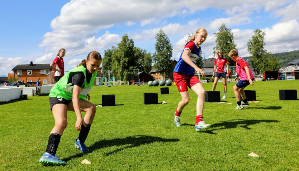 To jenter på vei tilbake for å hente hver sin siste bit som ligger på gresset. De svarte puslekassene i bakgrunnen.