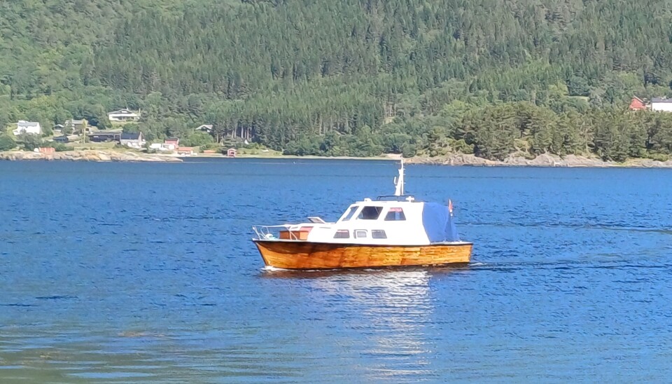På Ilabukta putrer en fin trebåt. En liten trebåt på fjorden.