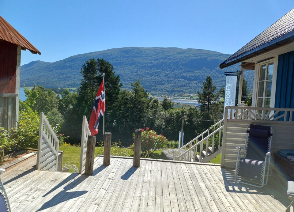 Utsikt ut fjorden fra Atelier Fjordblå. En treplatting foran et hus.